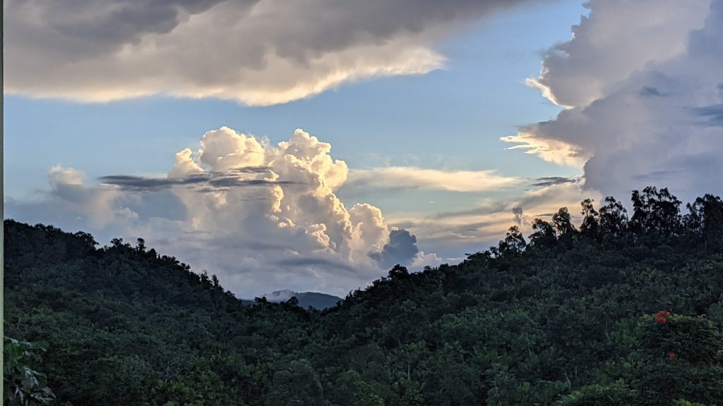 A photograph of the clouds and he tops of some mountains. Looking due east on Finca Kaleli.